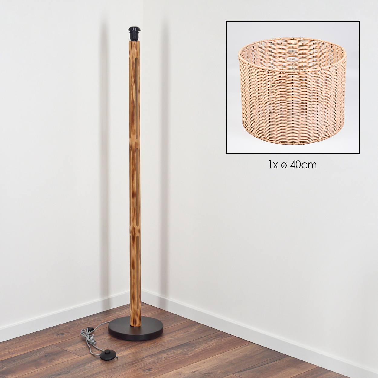 Eine Stehlampe mit Holzstange und schwarzem Fuß, neben einem Lampenschirm aus Korbgeflecht. Die Lampe steht auf einem Holzboden, nahe einer weißen Wand.