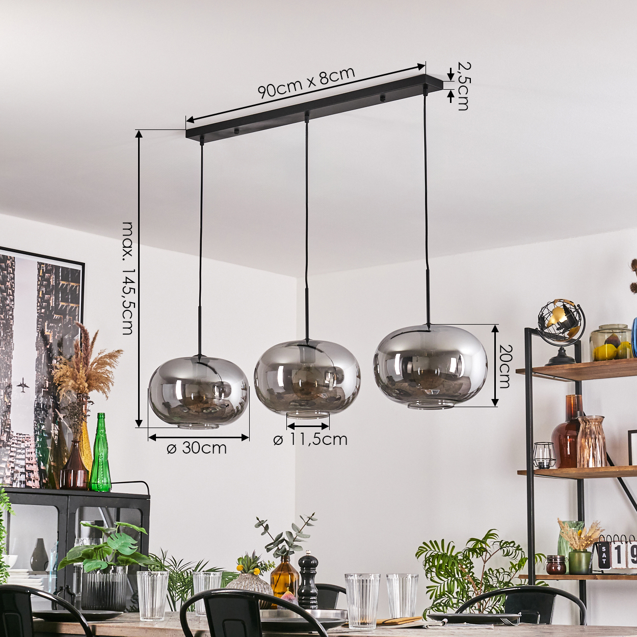 Drei verspiegelte Glashängeleuchten über einem Esstisch. Abmessungen sind beschriftet. Im Hintergrund ein Regal mit Dekoration.