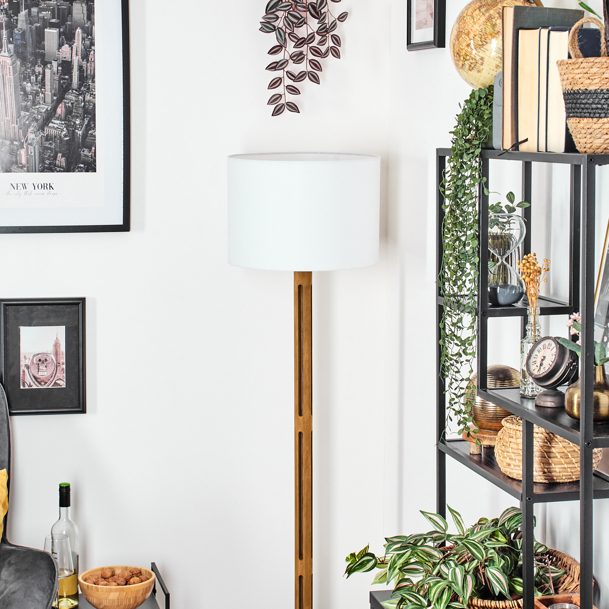 Ein Raum mit Lampe, Bücherregal und Dekoartikeln. Ein New York Bild und eine Schüssel mit Walnüssen sind sichtbar.