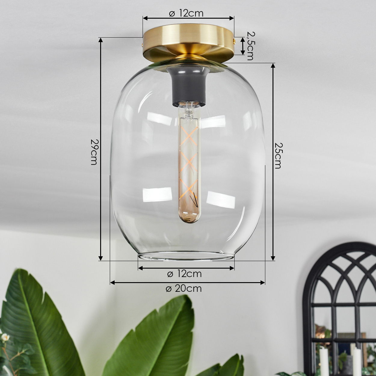 Eine moderne Deckenlampe mit goldfarbenem Sockel und klarem Glasschirm. Eine dekorative Glühbirne ist innen. Abmessungen sind mit Pfeilen angezeigt.