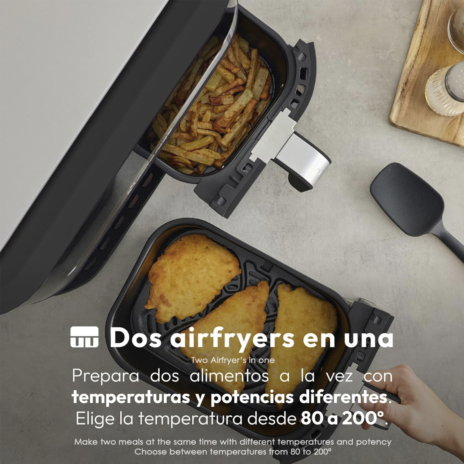 Una friggitrice ad aria con due scomparti. Uno ha patatine fritte, l'altro cibo fritto. Una mano tiene la friggitrice ad aria.