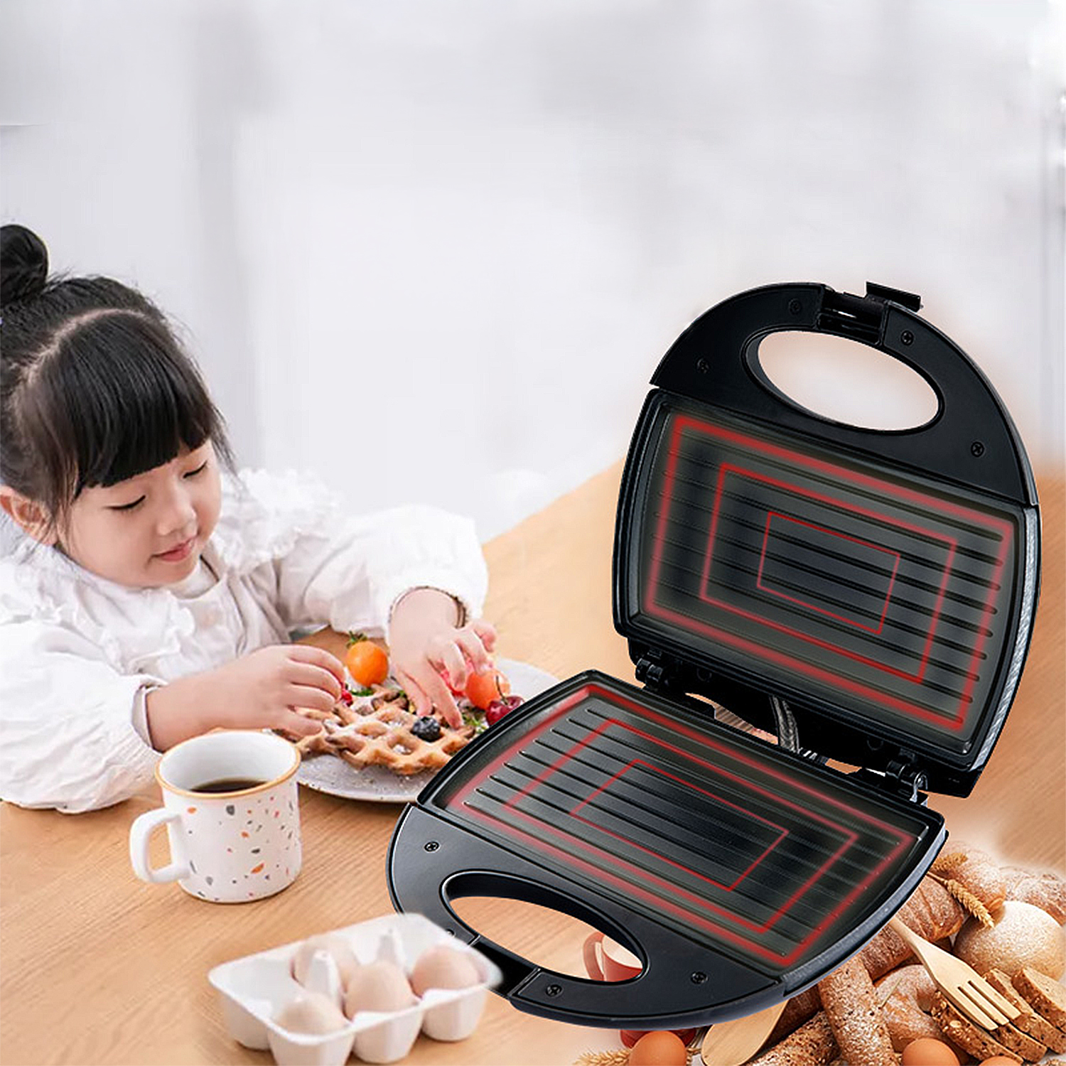 Ein Mädchen steht in der Nähe eines Waffeleisens und eines Sandwichmakers. Eier, eine Tasse und Brot liegen ebenfalls auf dem Tisch.