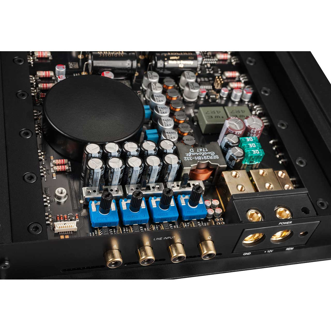 Elektronische Bauteile auf einer Platine: Kondensatoren, Widerstände, Regler und Eingangs-/Ausgangsanschlüsse. Schwarze und blaue Bauteile sind sichtbar.