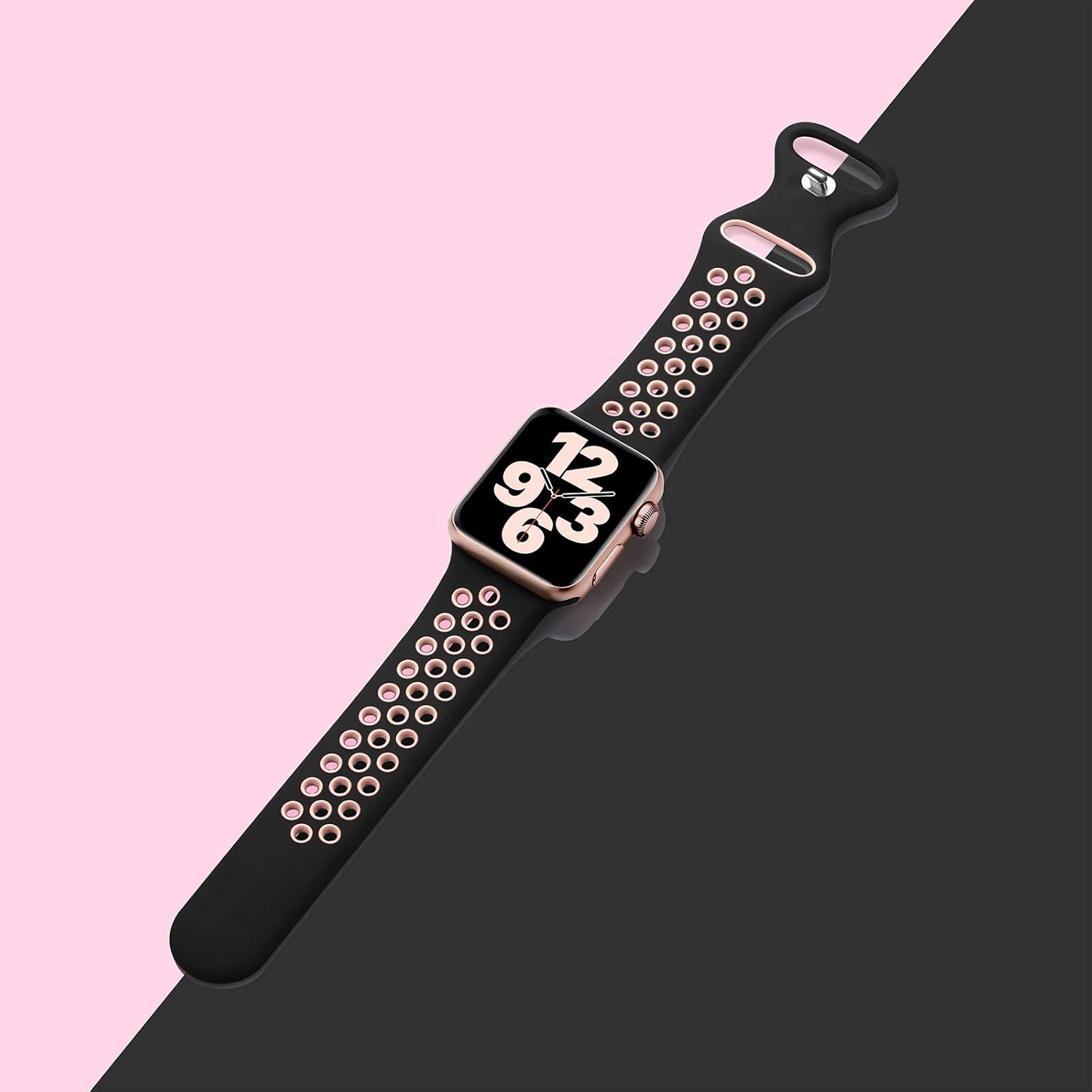 Eine Apple Watch mit einem schwarzen und rosa Armband, goldenem Zifferblatt und der Hintergrund ist in Rosa und Schwarz geteilt.