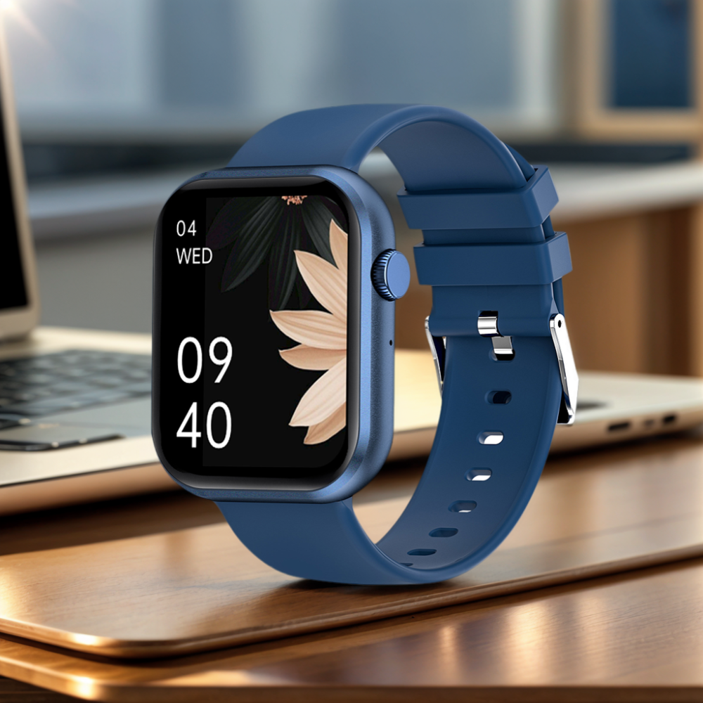 Eine blaue Smartwatch mit schwarzem Bildschirm, der Zeit und Datum anzeigt, liegt auf einer Holzoberfläche. Im Hintergrund ein Laptop.