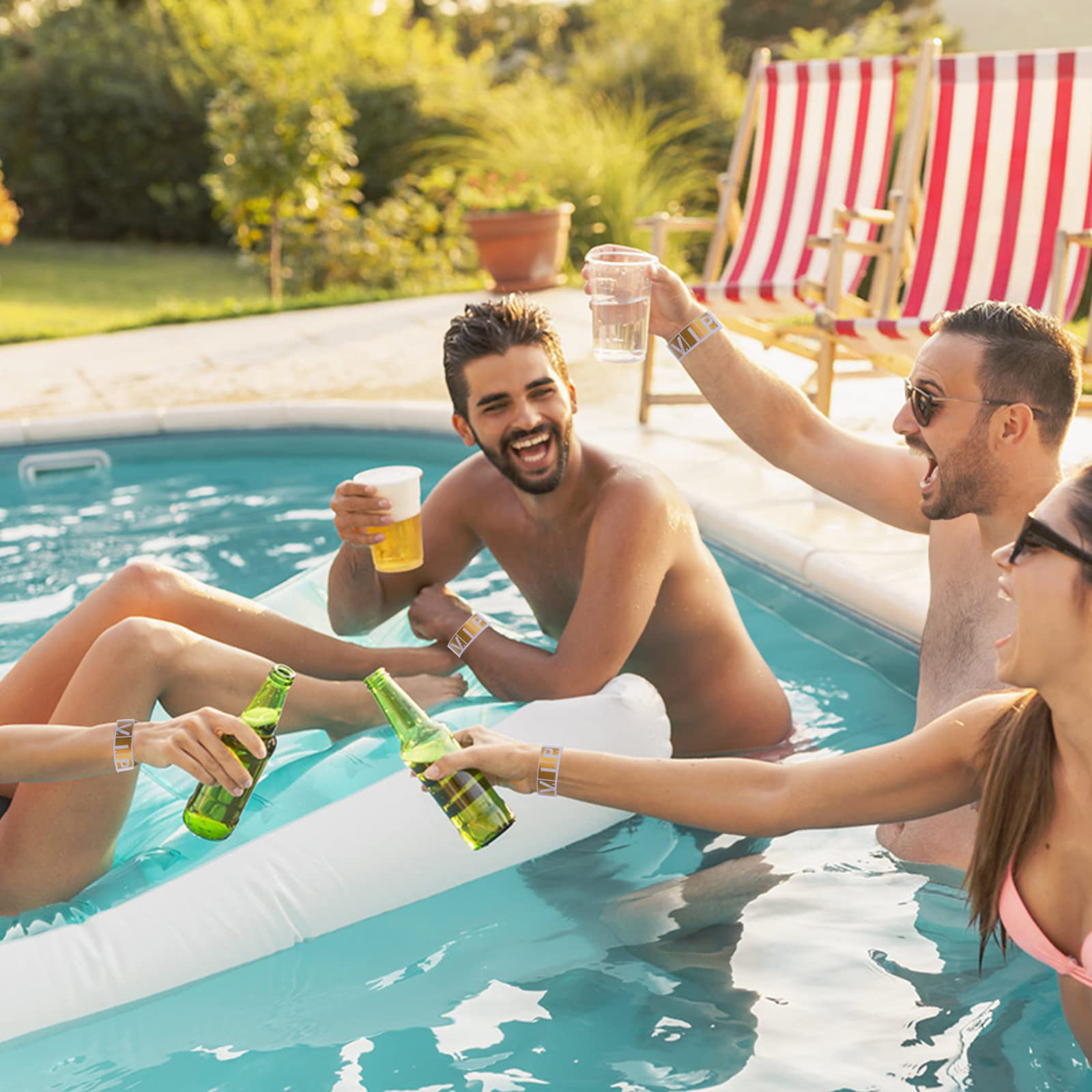 Freunde im Pool mit Getränken, lächelnd. Aufblasbares Floß, Poolstühle und grünes Laub im Hintergrund.