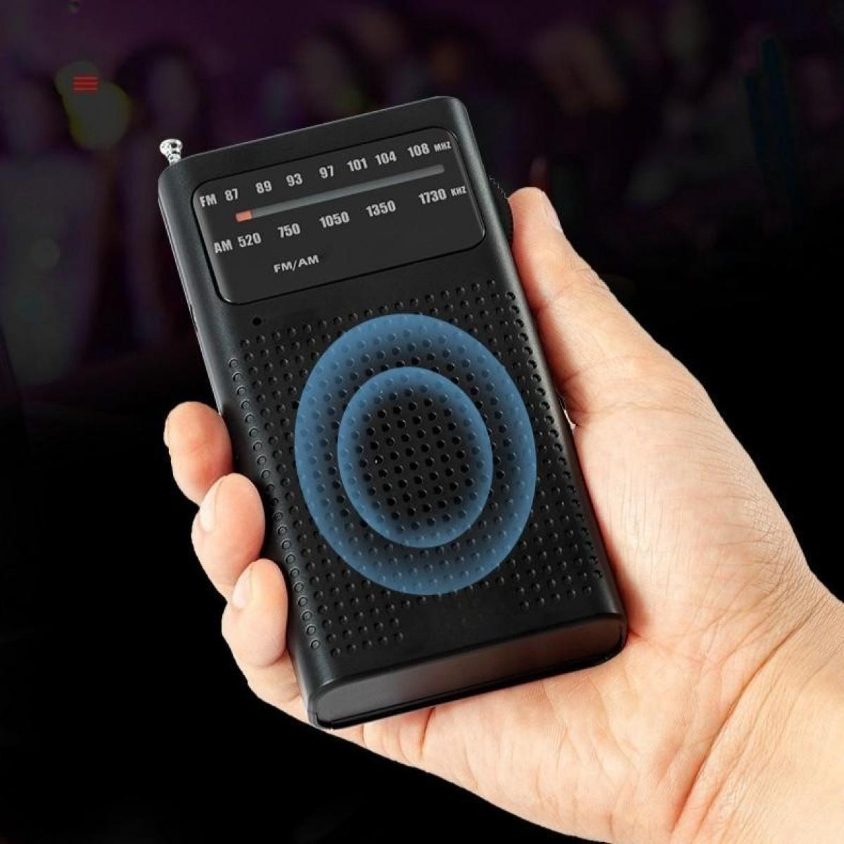 Eine Hand hält ein schwarzes Radio mit Frequenzeinstellungen. Das Radio hat ein blaues Kreismuster. Der Hintergrund ist dunkel.
