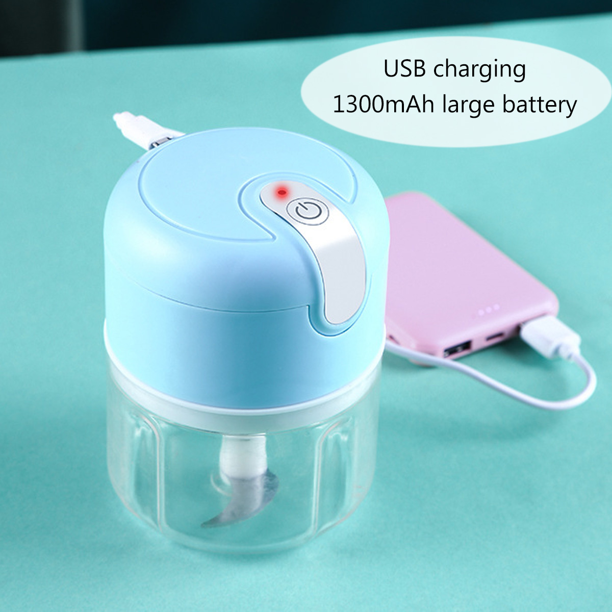 Ein blauer und klarer Foodprozessor steht neben einer pinken Powerbank. Ein weißes Kabel verbindet sie.