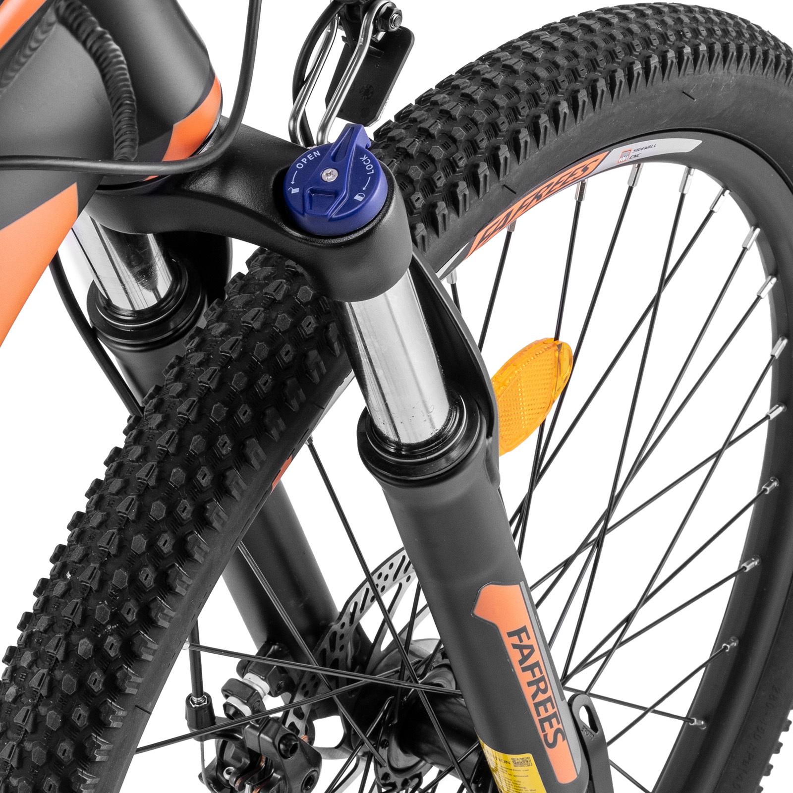 Zbliżenie przedniego koła czarno-pomarańczowego roweru. Opona jest czarna z głębokim bieżnikiem. Widoczne jest niebieskie pokrętło.