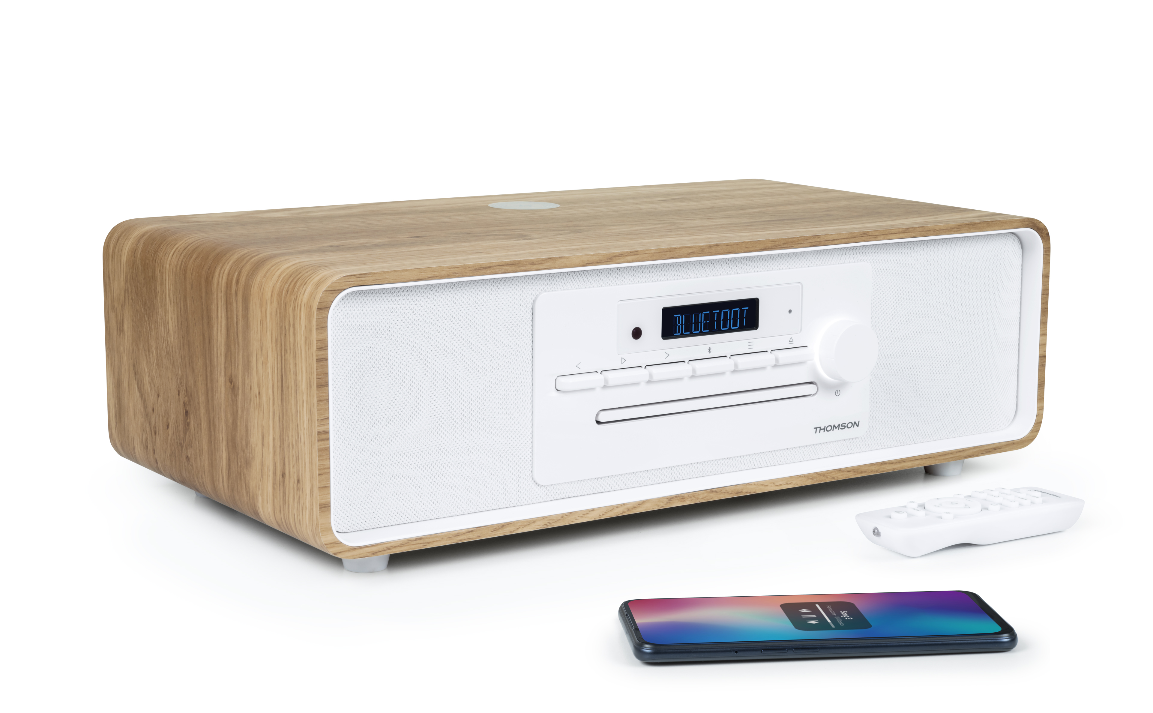 Drewniane radio z białym przodem i pilotem. Telefon z aplikacją muzyczną z przodu.