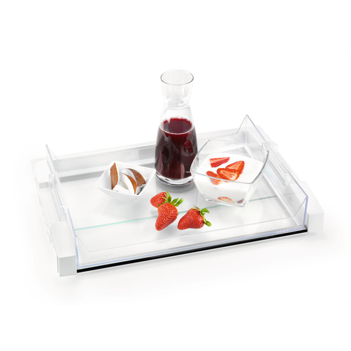 Taca ze szklaną karafką z czerwonym płynem, miska z kokosem, truskawkami i jogurtem z truskawkami.