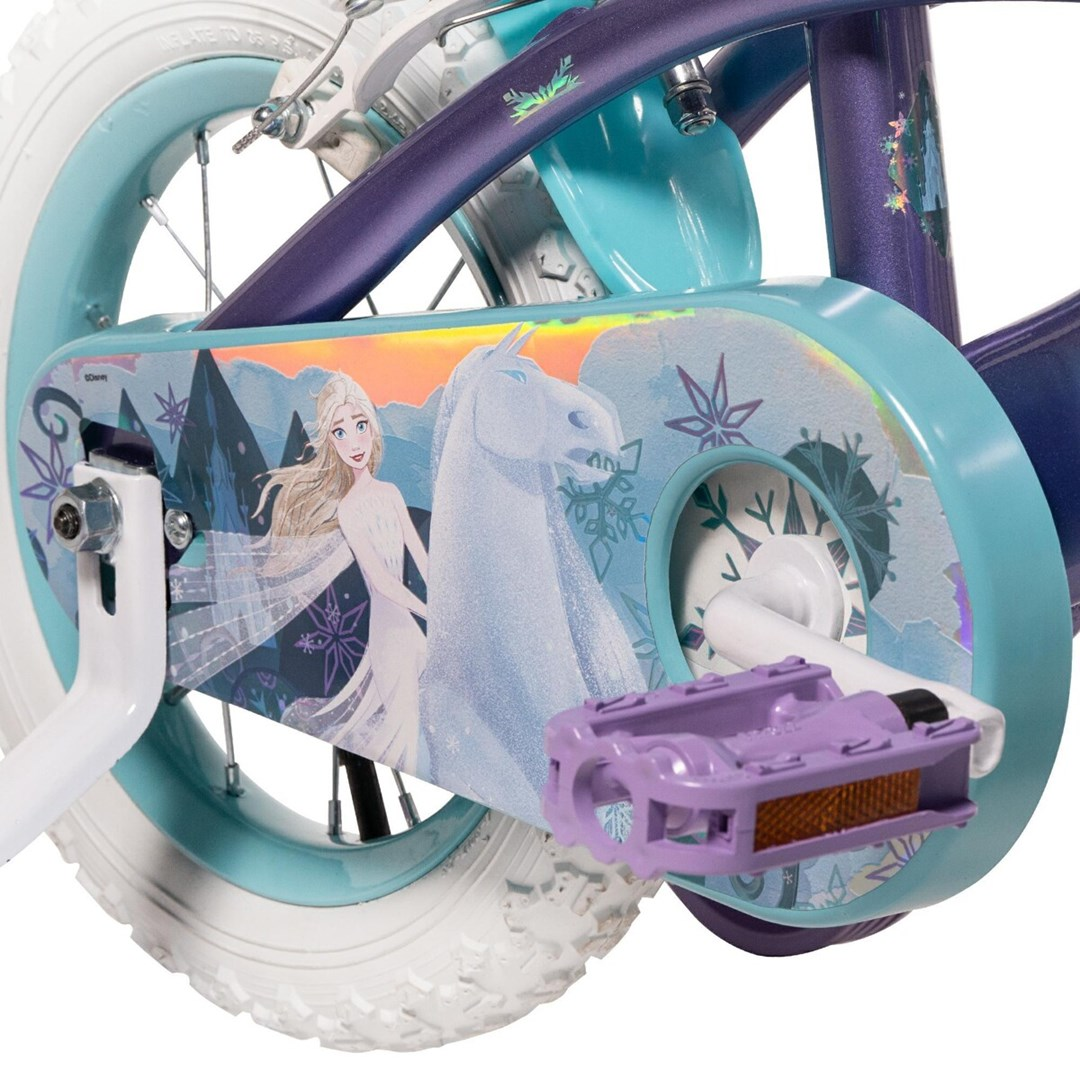 Nahaufnahme eines Fahrrads mit Frozen-Motiv. Der Rahmen ist lila und aqua, mit Elsa und einem Pferd auf dem Kettenschutz. Der Reifen ist weiß.