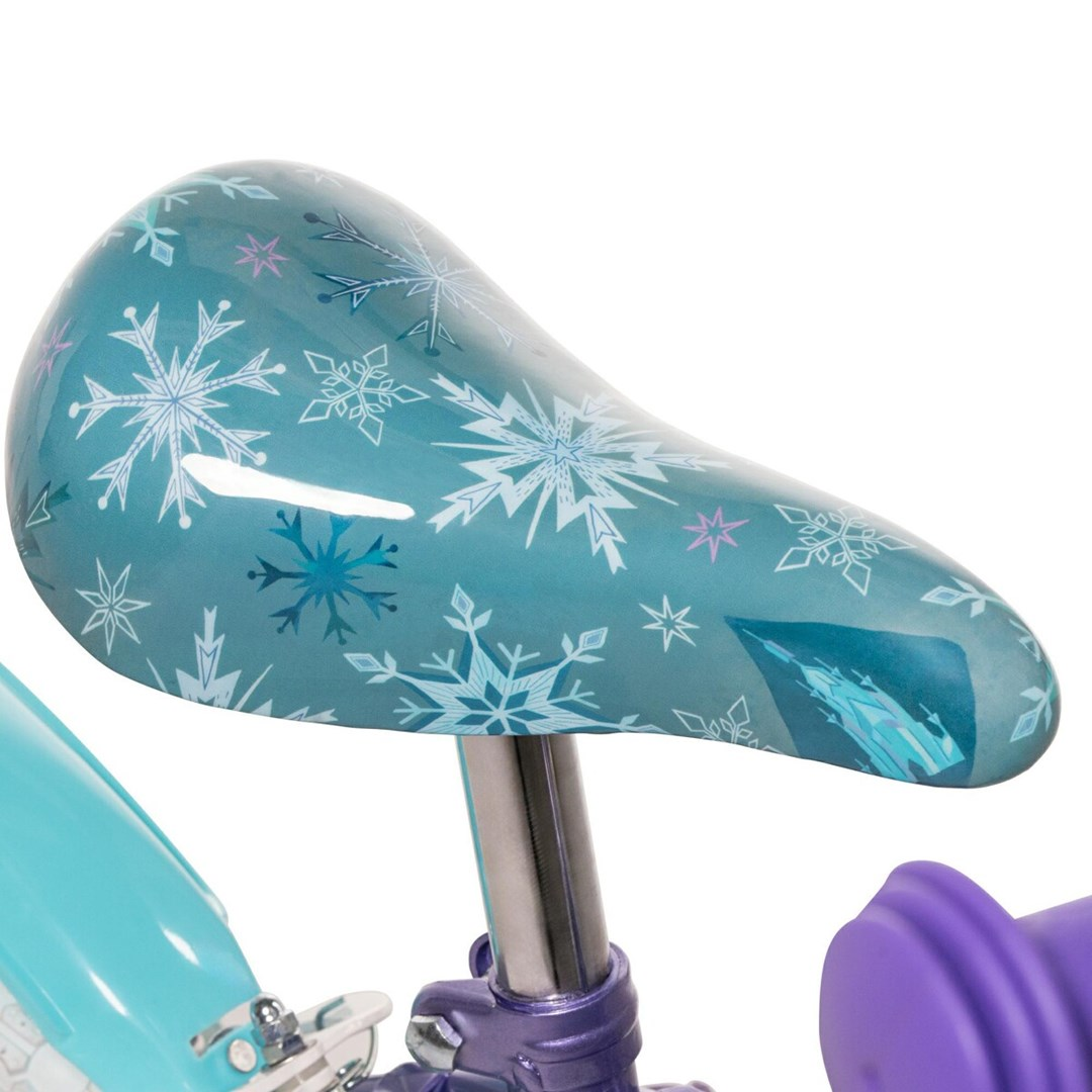 Fahrradsitz mit blau-weißem Schneeflockenmuster. Der Sitz ist türkis, lila und silber mit lila Lenker.