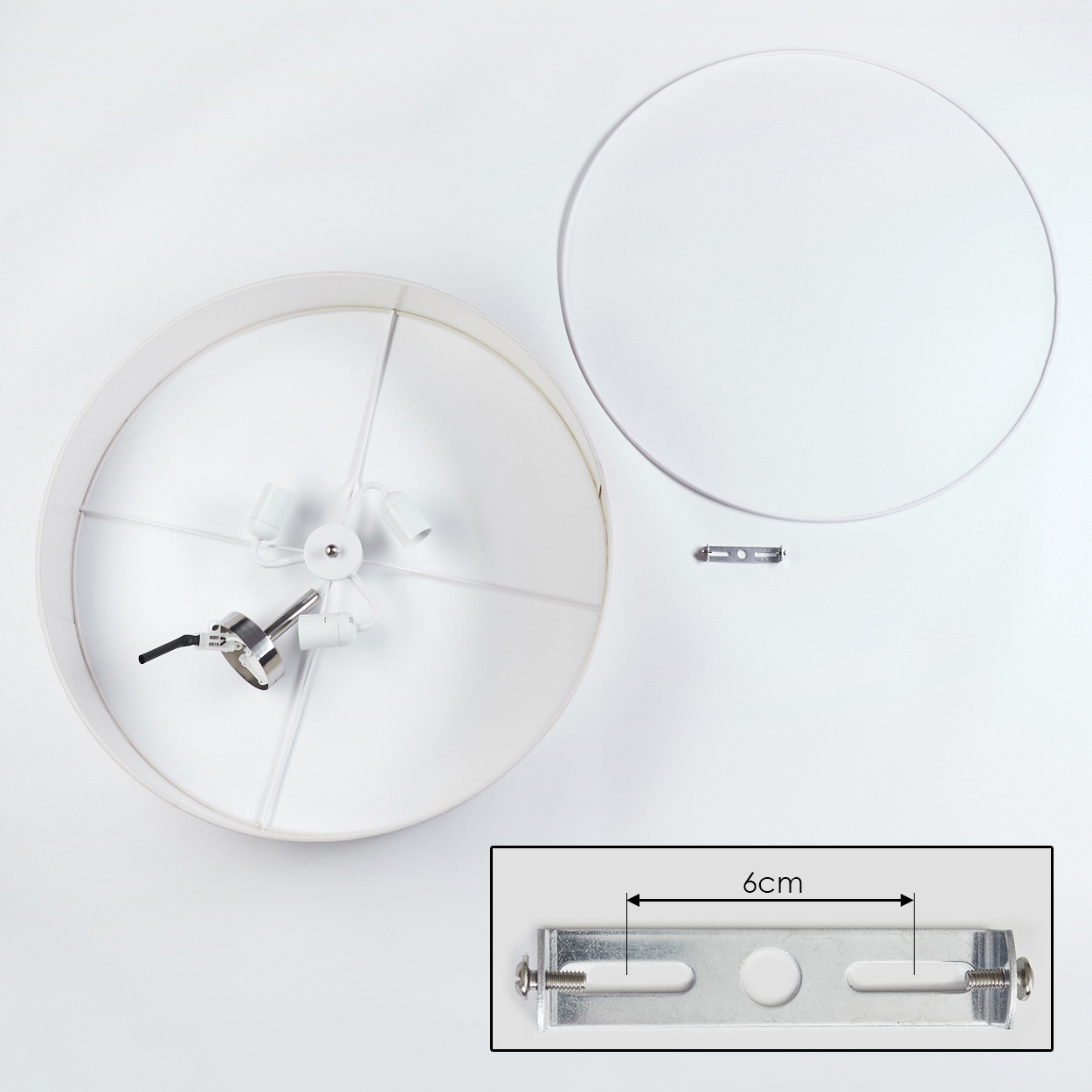 Draufsicht auf eine weiße Lampe mit rundem Schirm und separatem Ring. Komponenten umfassen eine Halterung und Leuchten.