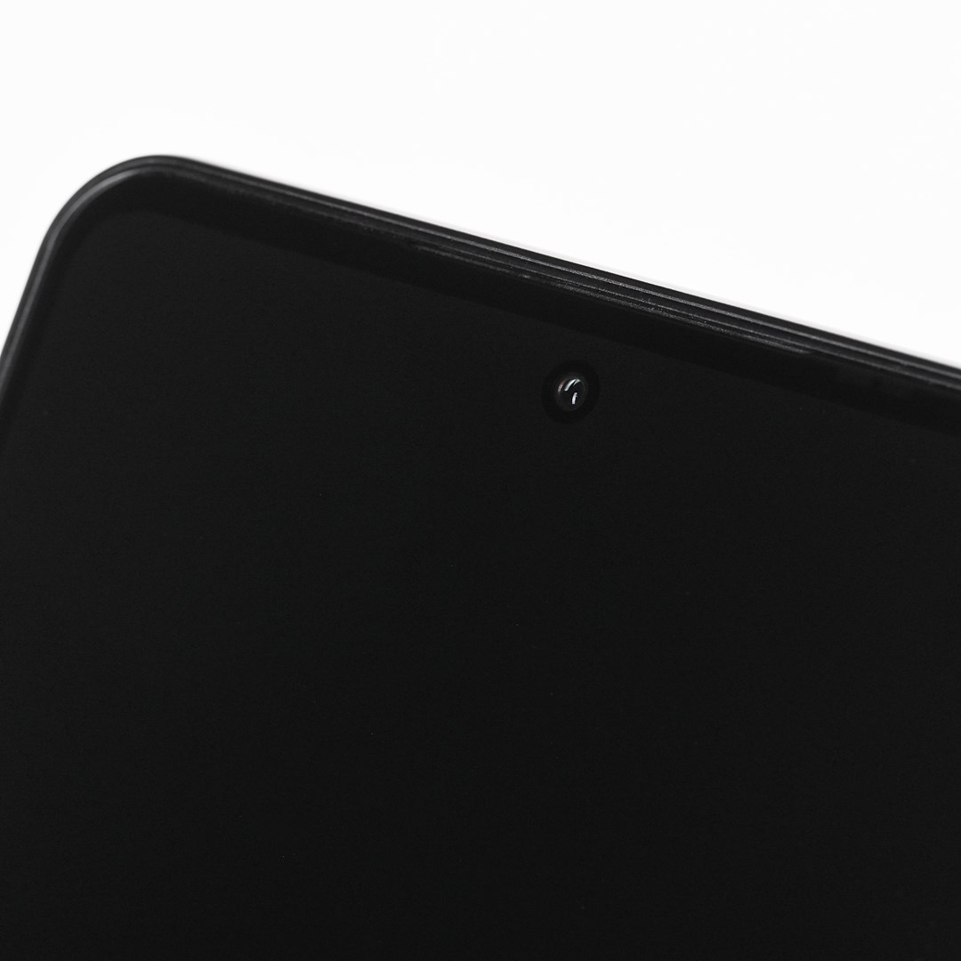 Zbliżenie czarnego ekranu smartfona z aparatem. Ekran ma zaokrąglone rogi. Białe tło.