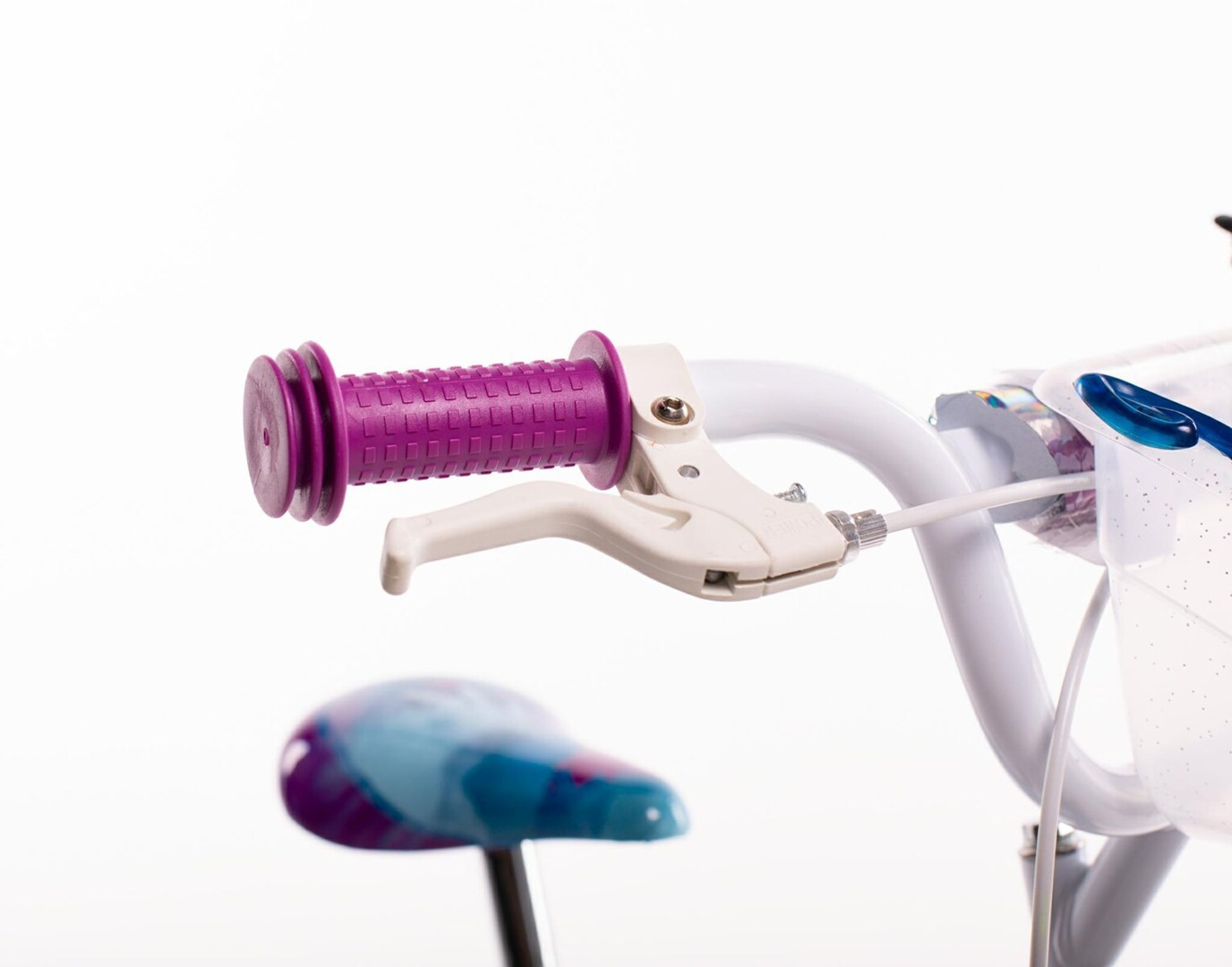 Zbliżenie kierownicy roweru z fioletowym uchwytem. Widoczna jest biała dźwignia hamulca, siodełko w tle.