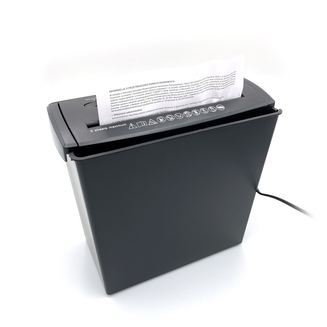 Ein schwarzer Aktenvernichter mit eingelegtem Papier. Der Aktenvernichter steht auf einer weißen Oberfläche.