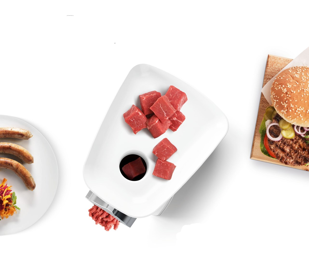 Maszynka do mięsa z surowym mięsem, kiełbasa na talerzu i burger na drewnianej desce na białym tle.