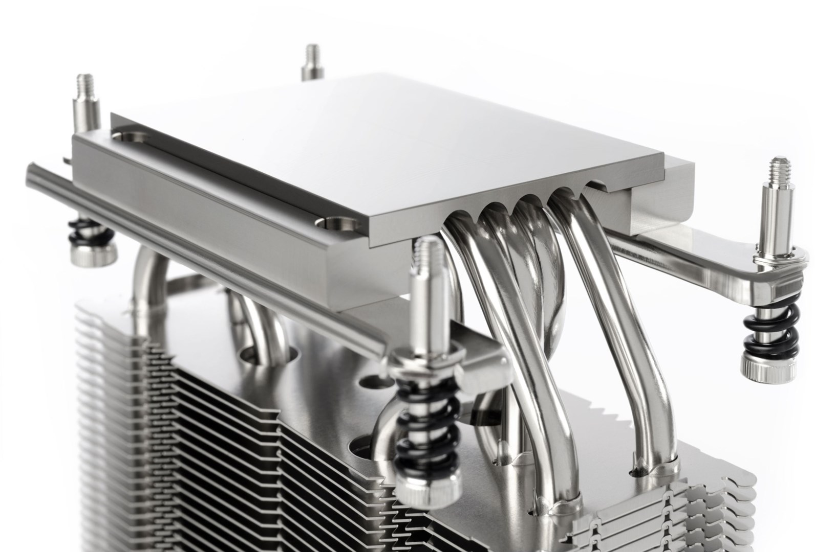 Zbliżenie srebrnego chłodzenia procesora z rurkami cieplnymi i żeberkami na białym tle. Komponenty są metaliczne i odbijające światło.