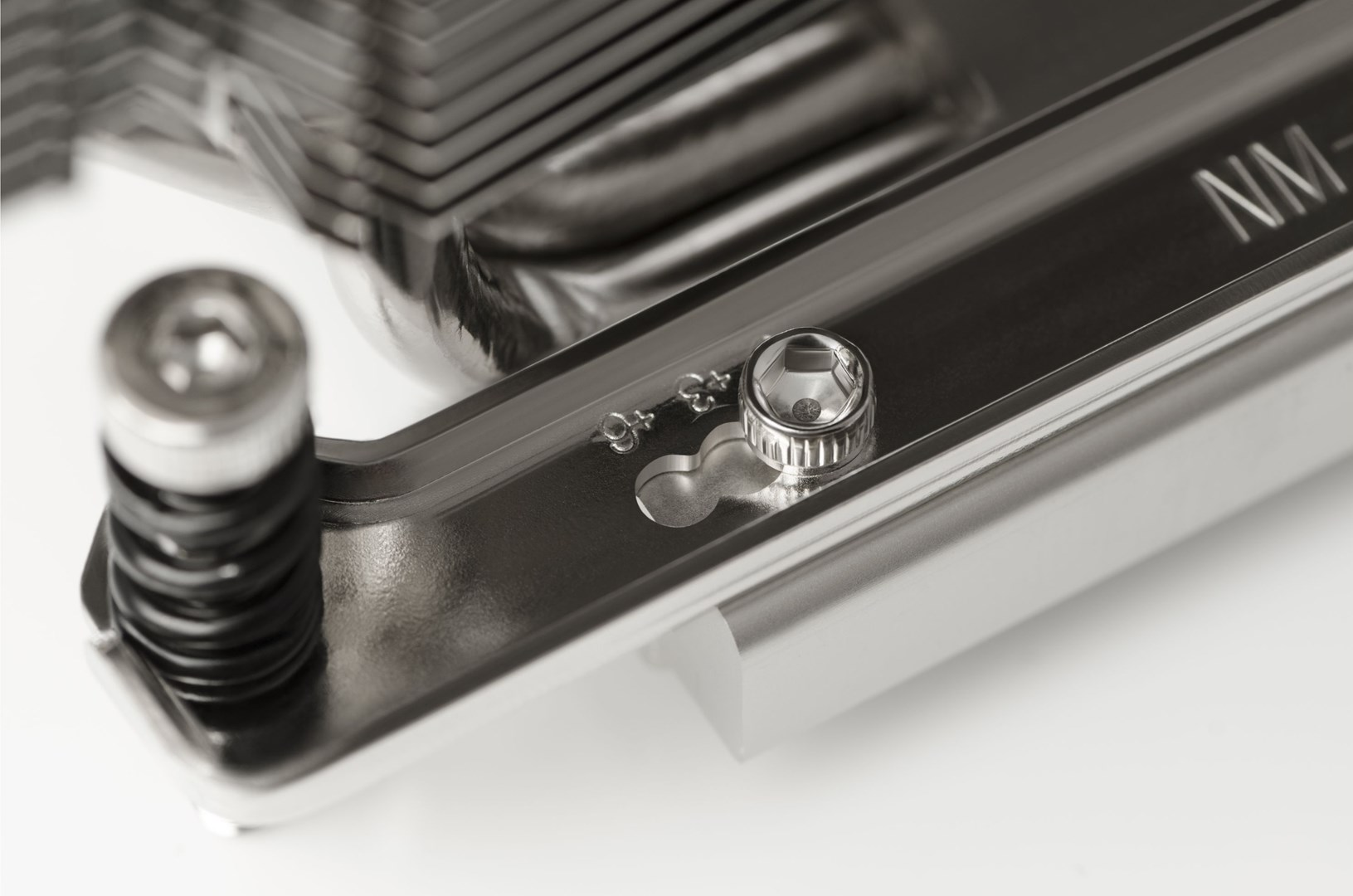 Zbliżenie metalowego elementu komputera ze śrubą i gniazdem sześciokątnym. Srebrny kolor, z innymi częściami widocznymi w tle.