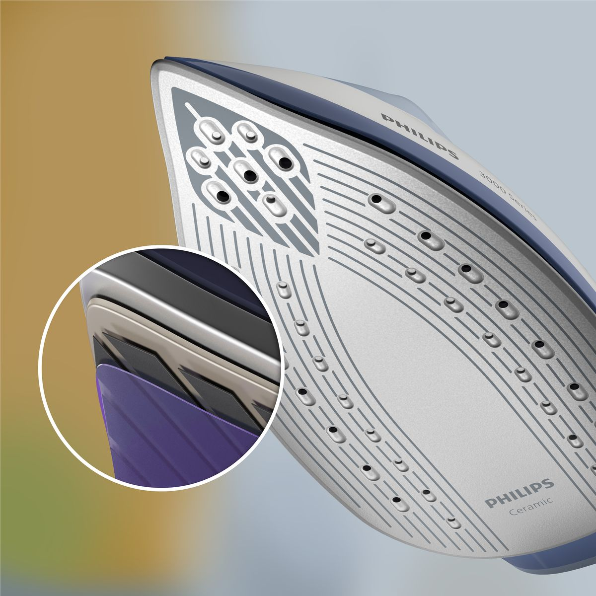 Zbliżenie żelazka Philips. Żelazko jest biało-niebieskie z ceramiczną stopą. Powiększenie pokazuje jego warstwy. Tło jest rozmyte.