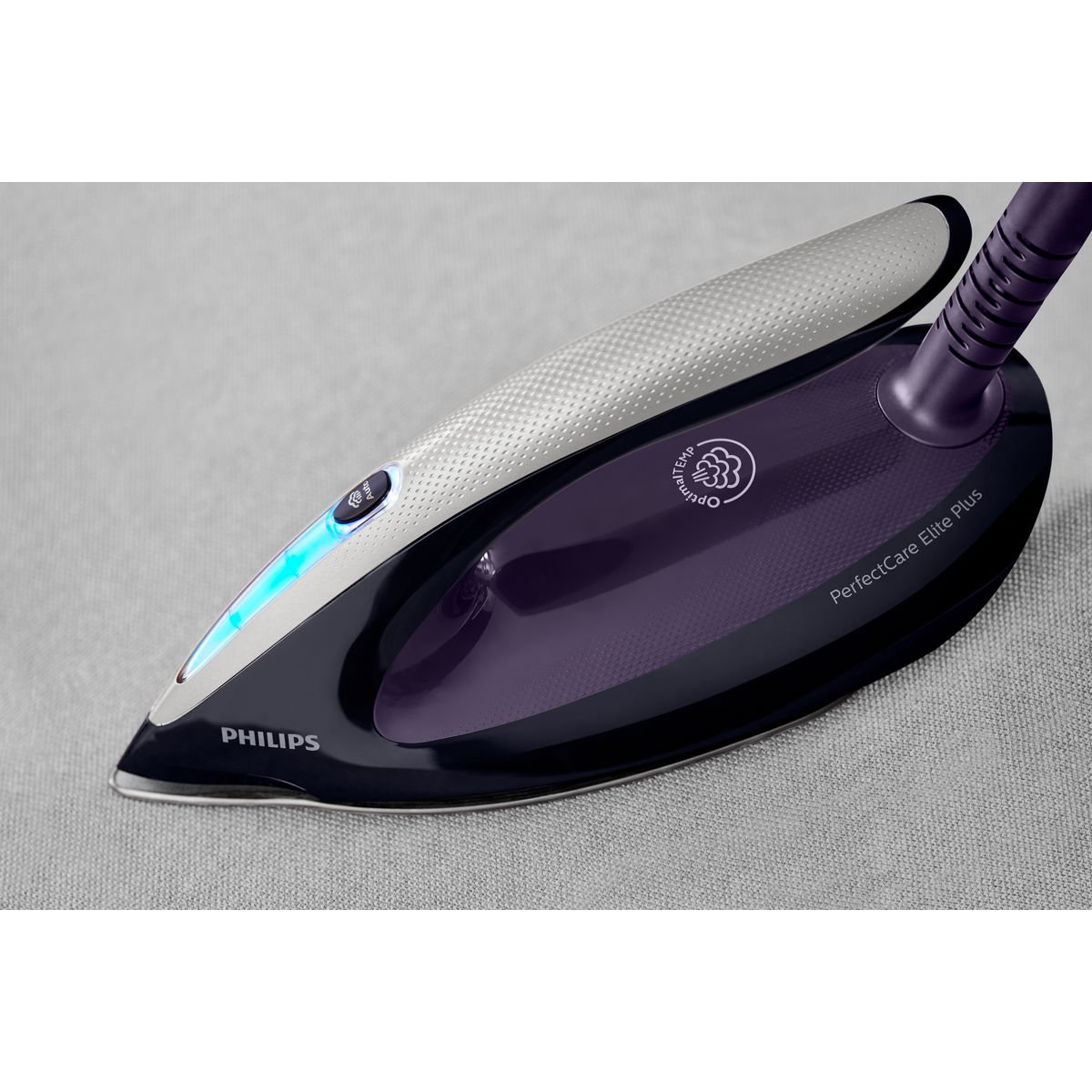 Ein Philips PerfectCare Elite Plus Bügeleisen. Es ist lila und silber, mit dem Philips-Logo, auf einem grauen Stoff.