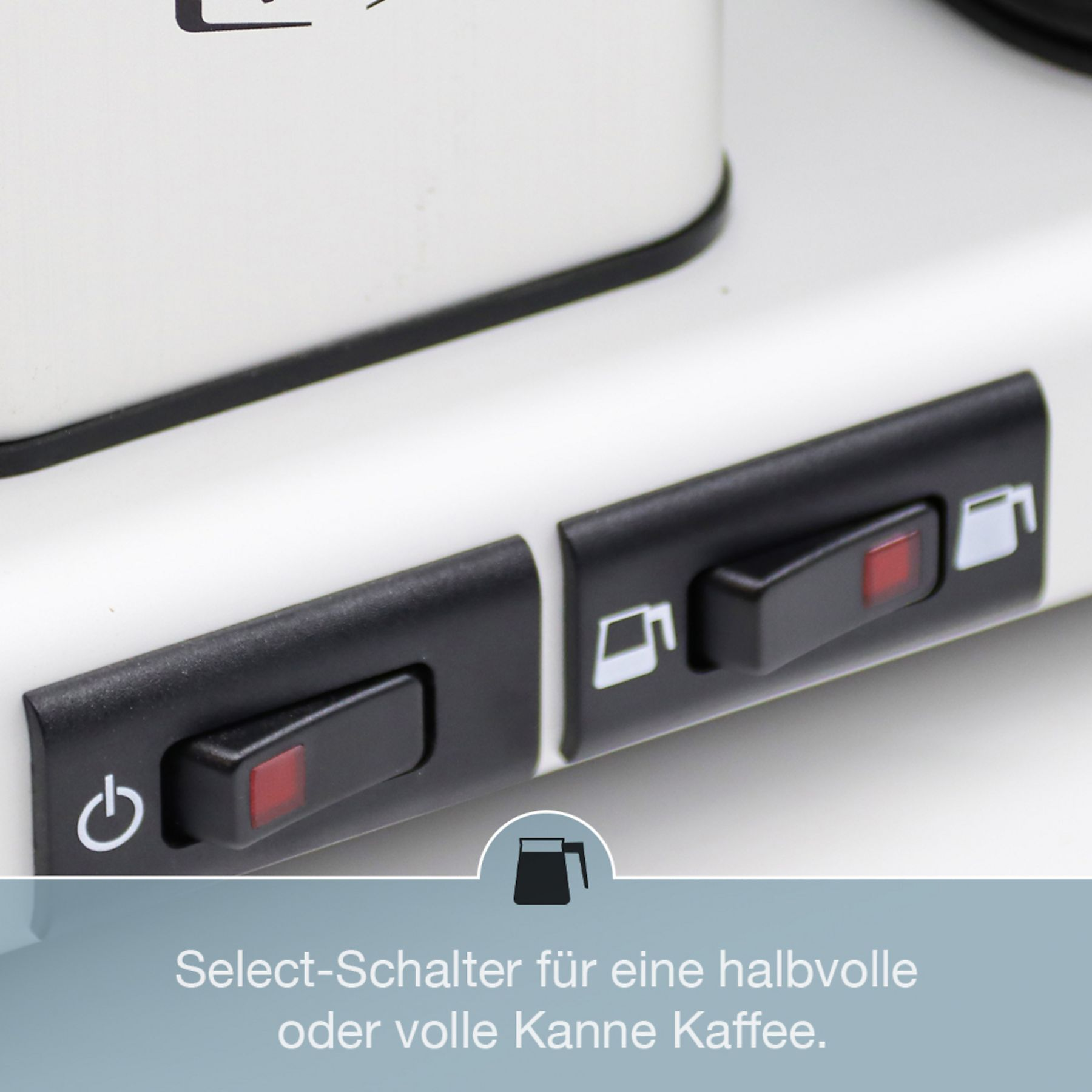 Zbliżenie ekspresu do kawy z czarnymi przełącznikami. Widoczne są dwa przełączniki.