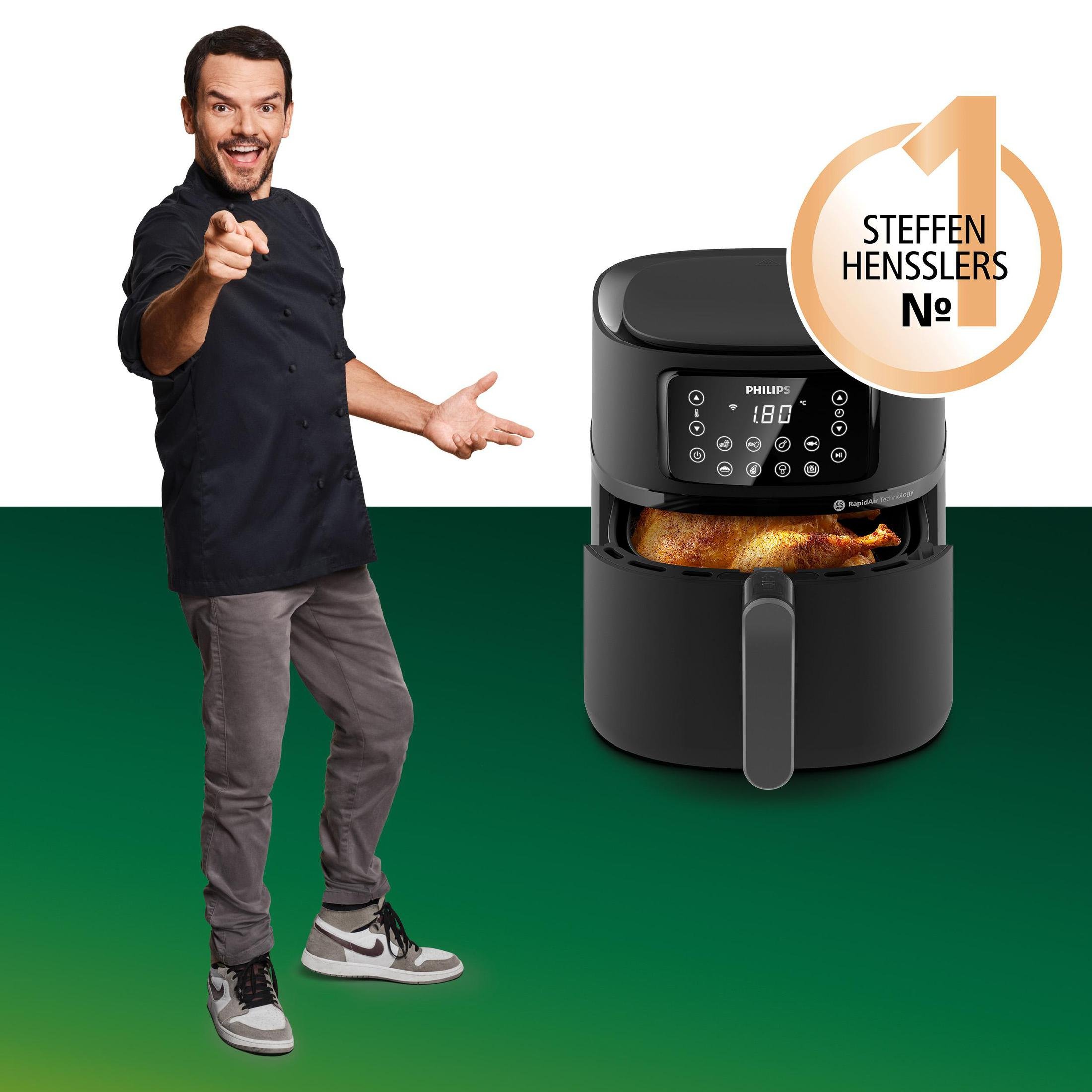 Mann in Kochkleidung zeigt auf den Betrachter. Rechts ein schwarzer Airfryer, mit 'Steffen Henssler' Label.