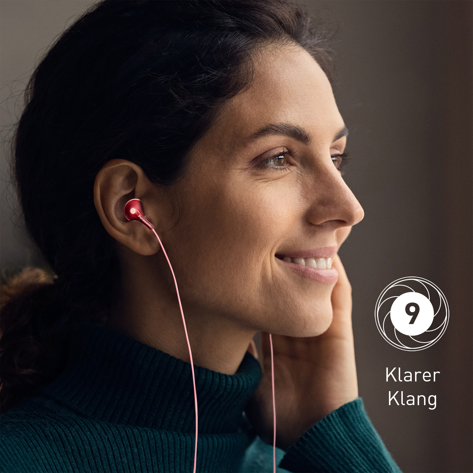 Eine lächelnde Frau mit roten Kopfhörern. Sie trägt einen grünen Pullover. Ein Logo mit der Zahl 9 ist rechts.