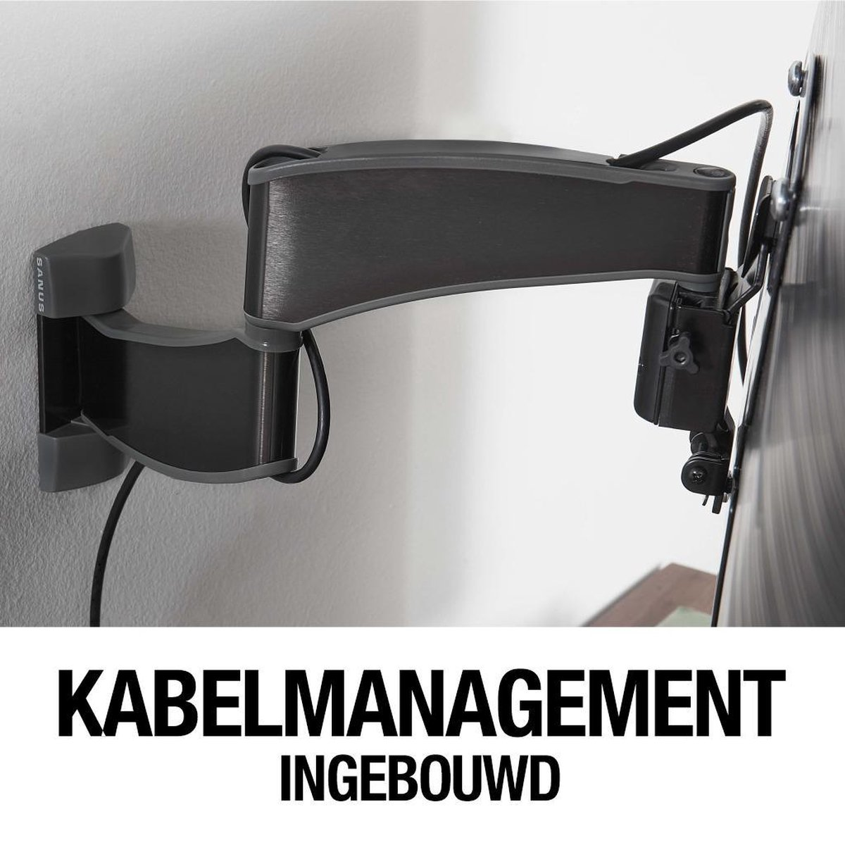 Un supporto a parete per TV grigio scuro con gestione dei cavi. Il supporto è installato su una parete bianca. Il testo dice 'KABELMANAGEMENT INGEBOUWD'.