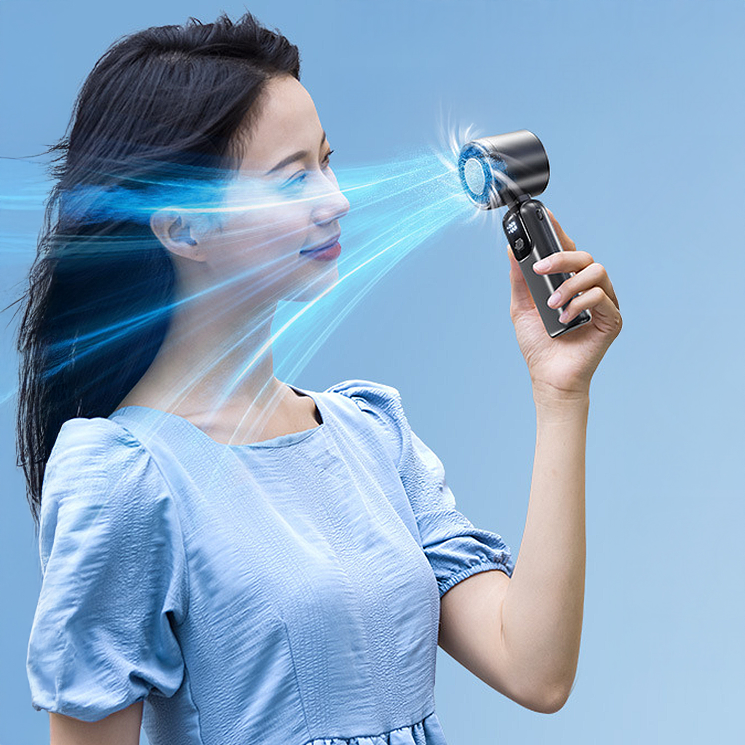 Una mujer sostiene un ventilador negro, con rayos de luz azul que emanan hacia su rostro. Viste un vestido azul, con fondo azul.