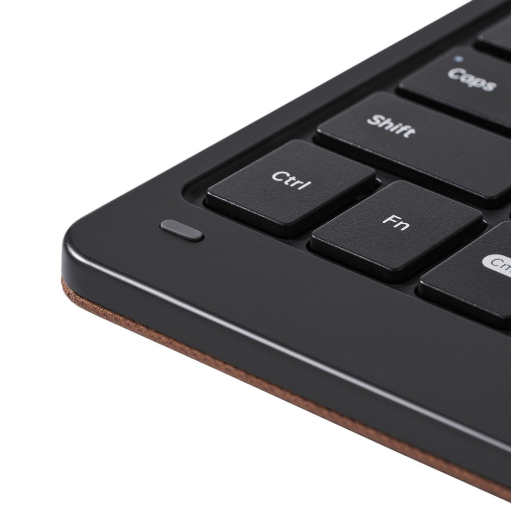 Nahaufnahme einer schwarzen Tastatur mit weißen Buchstaben. Die Tasten 'Ctrl', 'Fn', 'Shift' und 'Caps' sind sichtbar. Die Tastatur hat einen braunen Rand.