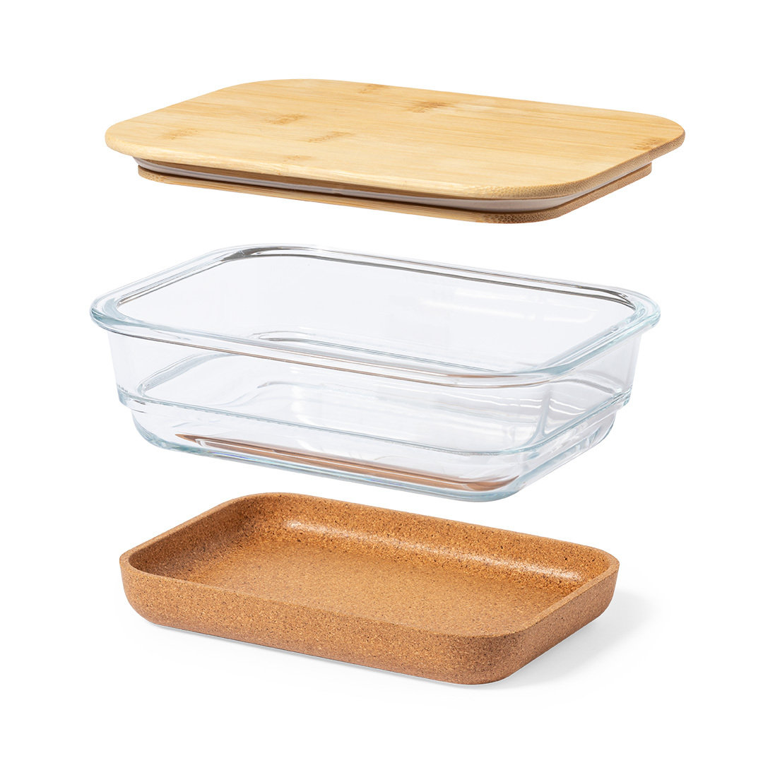 Un recipiente para alimentos desmontado. Tiene una tapa de bambú, un recipiente de vidrio transparente y una base de corcho, todo rectangular.