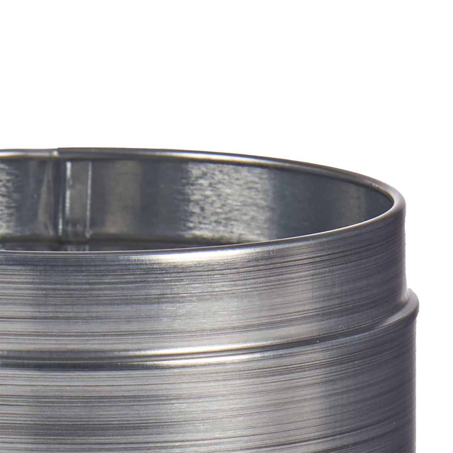 Primo piano di un oggetto metallico cilindrico con scanalature orizzontali. L'oggetto è grigio argento, su sfondo bianco.