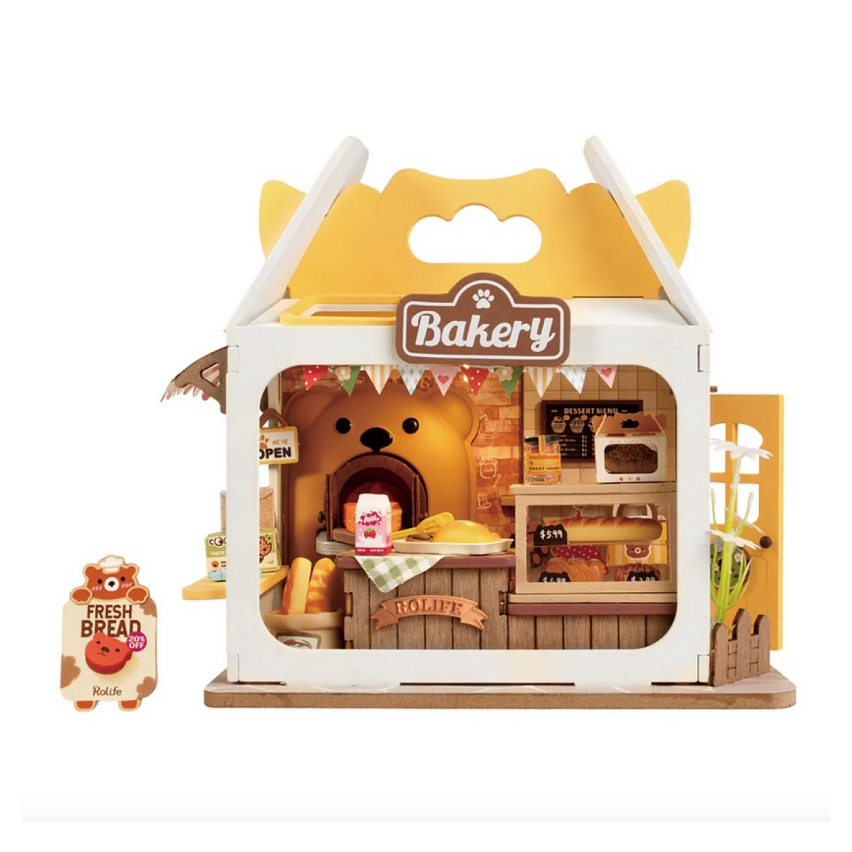 Una panetteria in miniatura con un forno a forma di orso. Ha pane, pasticcini e un cartello con scritto 'Pane fresco'. La panetteria è in una scatola.