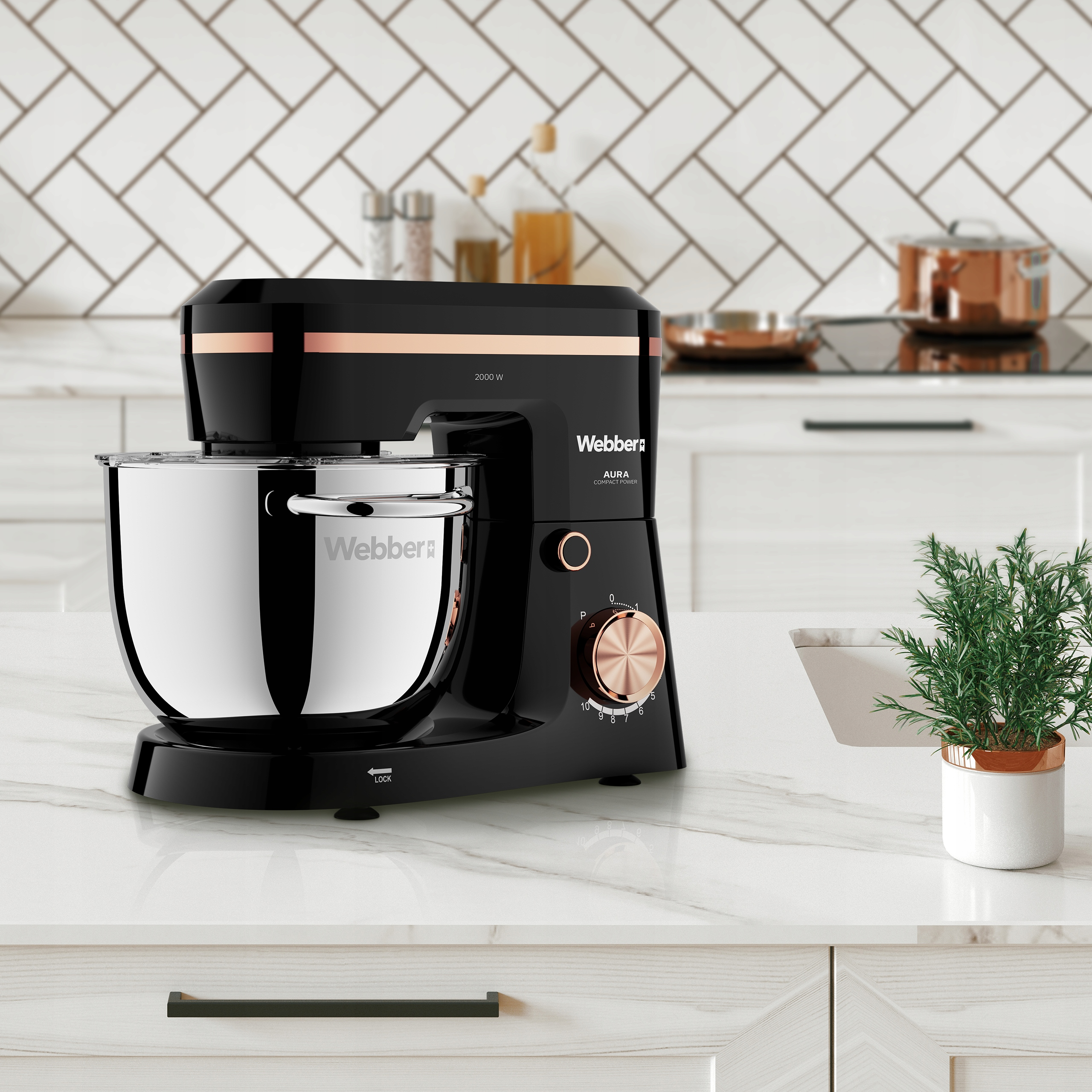 Czarny i srebrny mikser stojący Webber Aura na blacie, z małą rośliną po prawej stronie.
