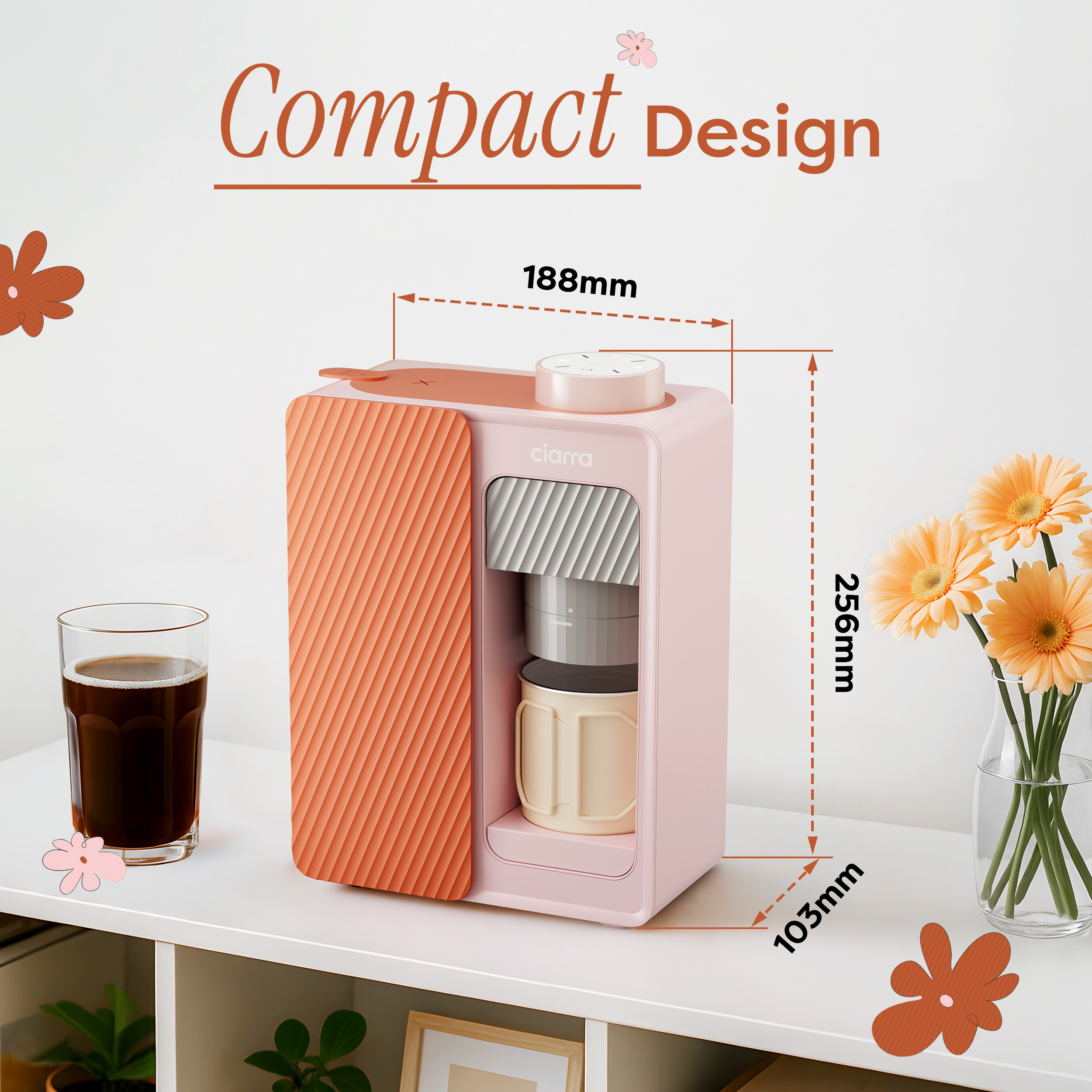 Ein rosa Kaffeemaschine mit orangefarbenen Akzenten steht auf einem weißen Regal. Ein Glas Kaffee und Blumen sind daneben.