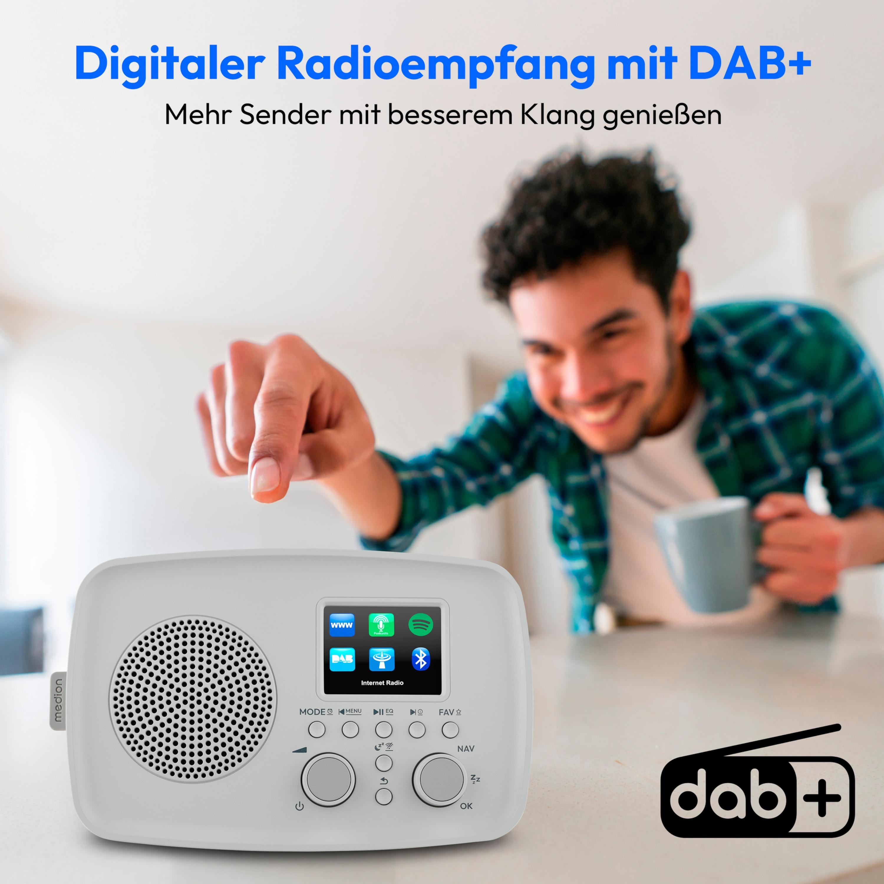 A man points at a white DAB+ radio. Text at the top says digital radio with DAB+. He smiles while holding a mug.