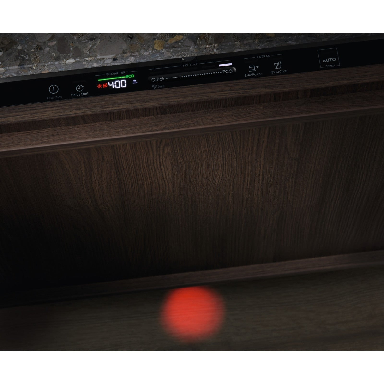 Pannello di controllo lavastoviglie con display ora. Mobile in legno sotto, luce rossa in basso.