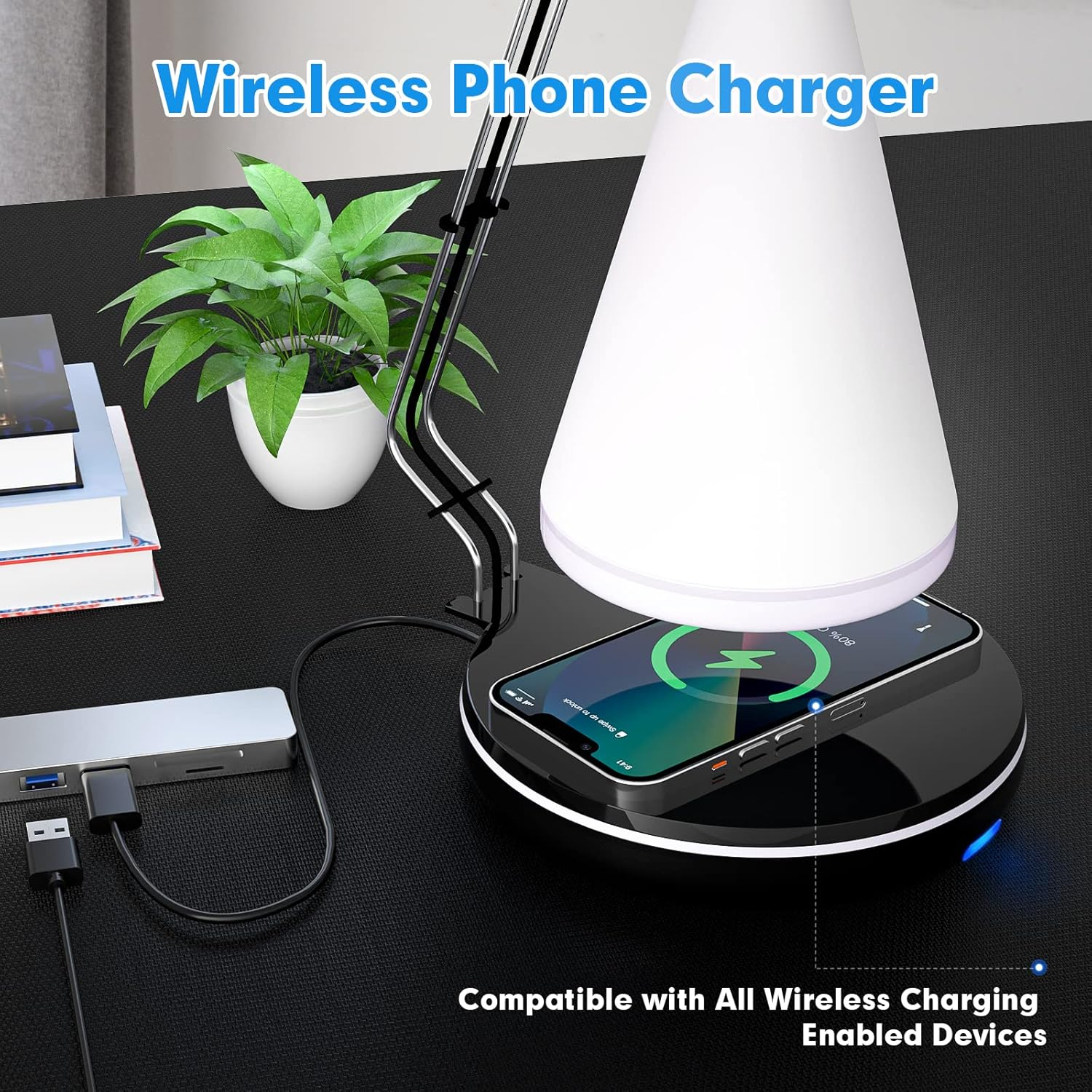 Ein Telefon auf einem kabellosen Ladegerät, eine Lampe, eine Pflanze und ein USB-Hub stehen auf einem schwarzen Schreibtisch.