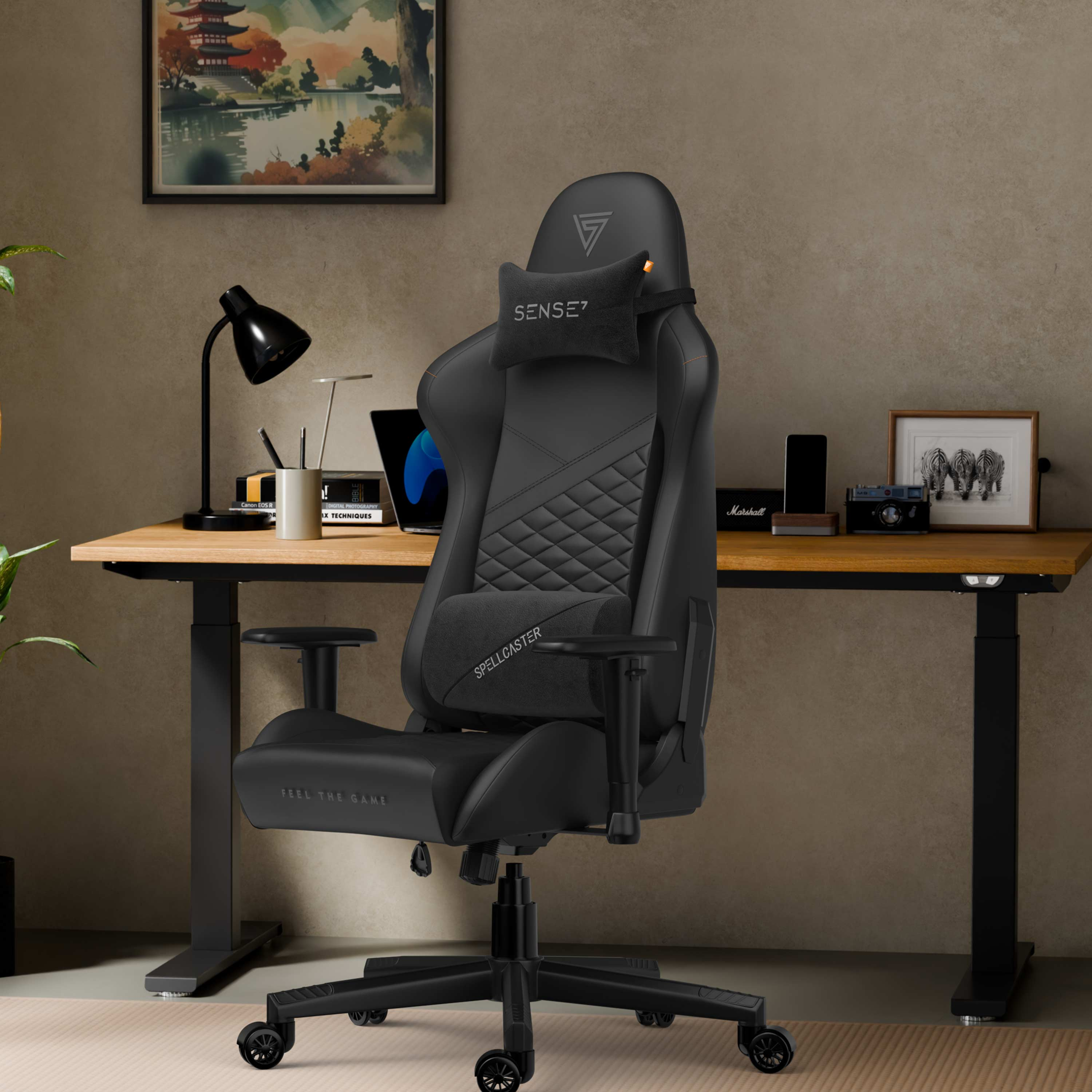 Zwarte gamestoel in een thuiskantoor. Bureau met lamp, laptop en accessoires. Muurkunst en plant zichtbaar.