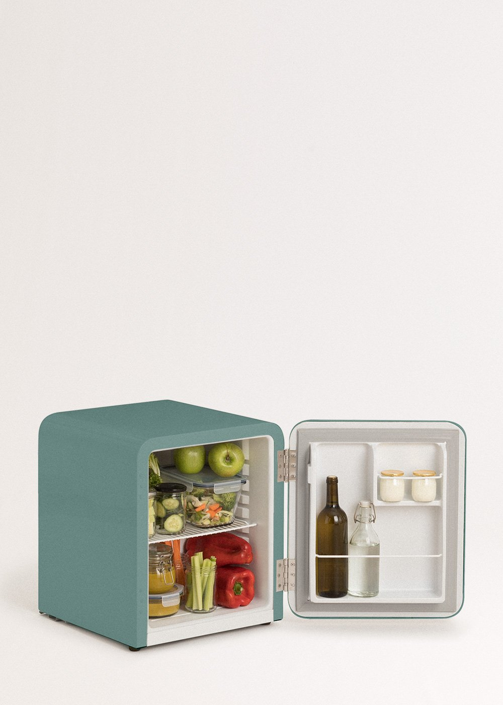 Un mini-refrigerador turquesa con la puerta abierta. Dentro hay frutas, verduras y frascos. La puerta abierta revela botellas y pequeños recipientes.