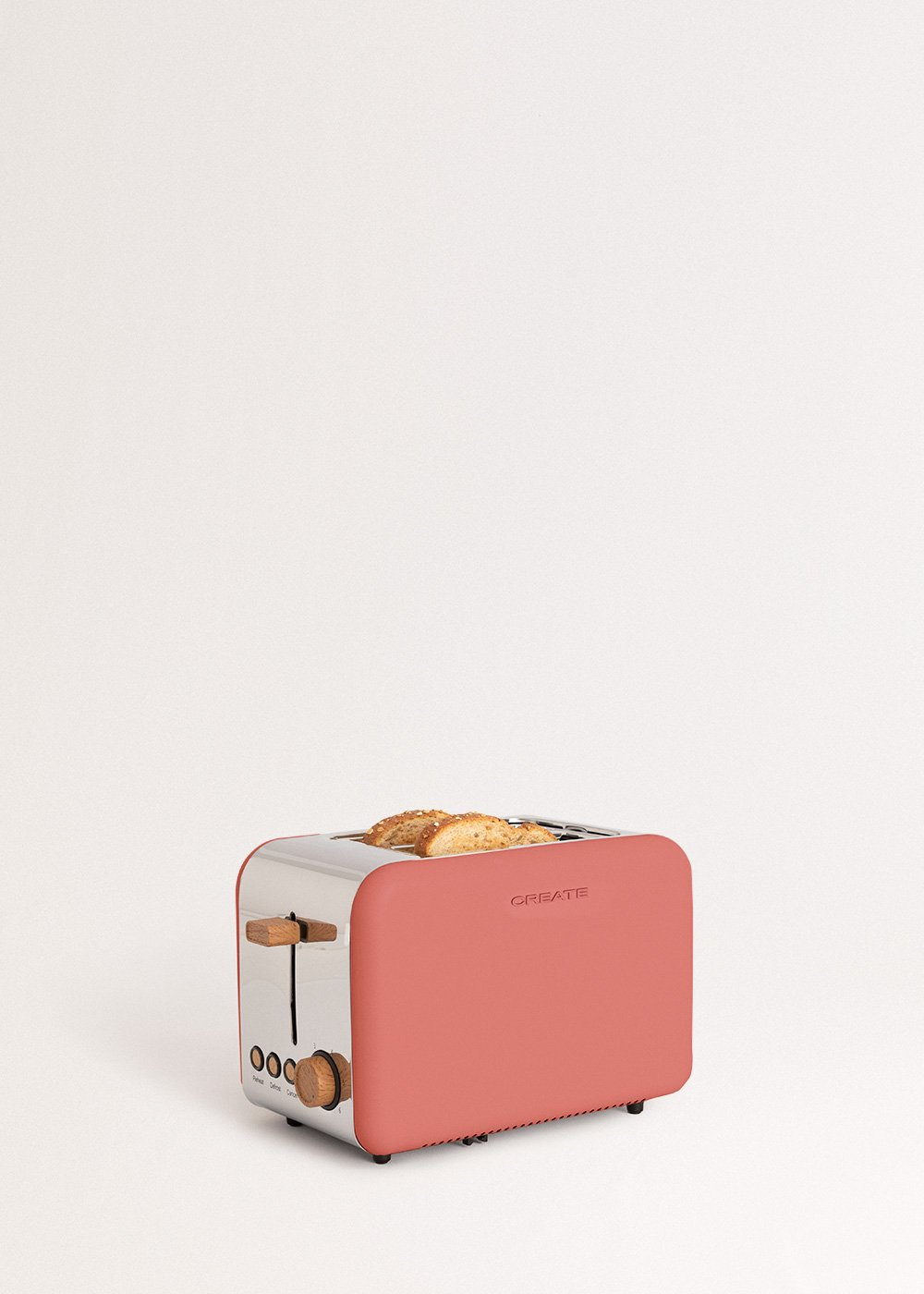 Una tostadora color coral con dos rebanadas de pan. Tiene detalles de madera y una parte superior plateada. La marca es 'CREATE'.