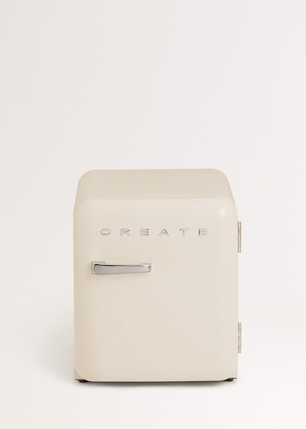 Mini nevera color crema con la palabra CREATE. Tiene un asa y bisagras plateadas. Sobre un fondo blanco.
