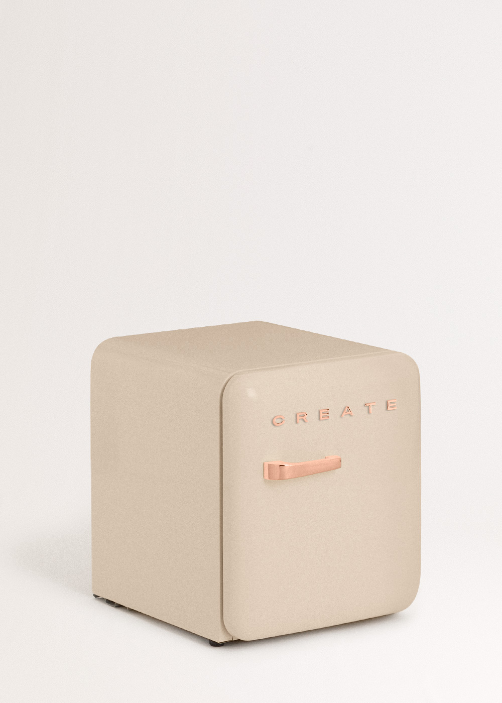 Un mini-refrigerador beige con manija de oro rosa y 'CREATE' al frente, sobre un fondo blanco.