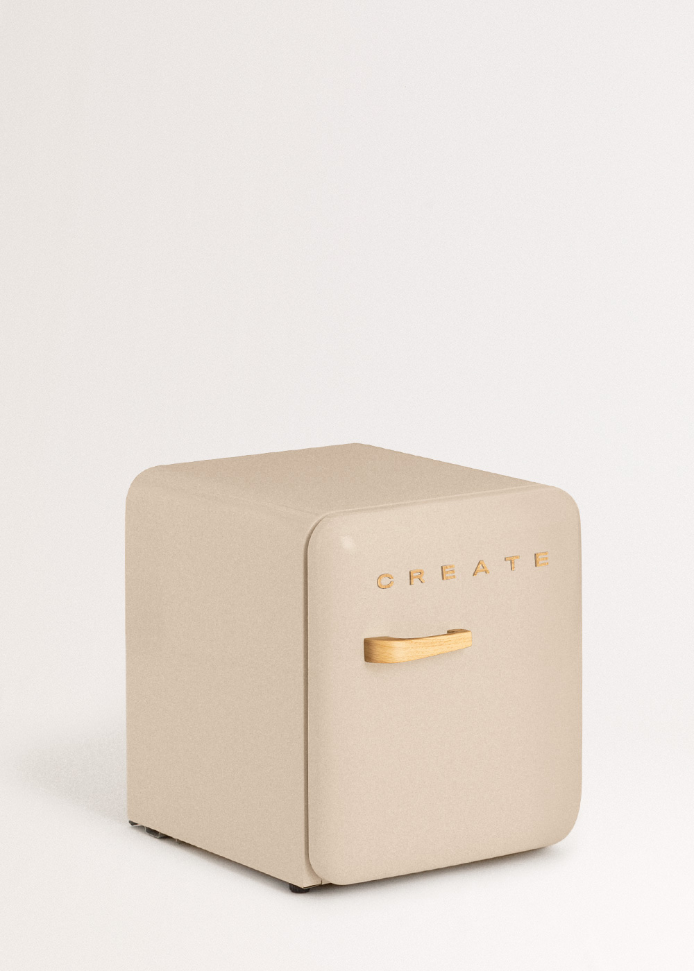 Un mini-refrigerador beige con la palabra 'CREATE' en letras doradas. Tiene un asa de madera y está sobre fondo blanco.