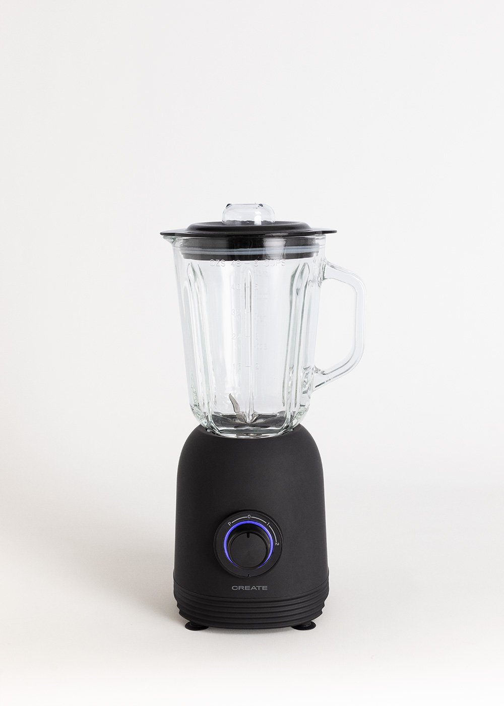 Ein schwarzer Mixer mit einem Glasbehälter und Deckel. Die Basis hat ein Zifferblatt und das Wort CREATE. Der Hintergrund ist weiß.