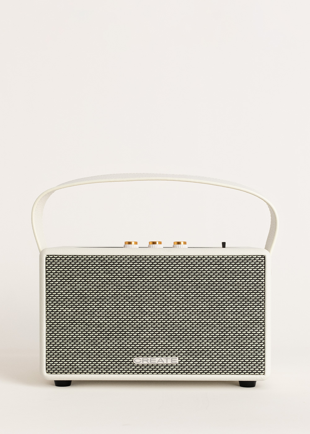 Un altavoz blanco y negro con asa, perillas y frontal estampado sobre fondo blanco.