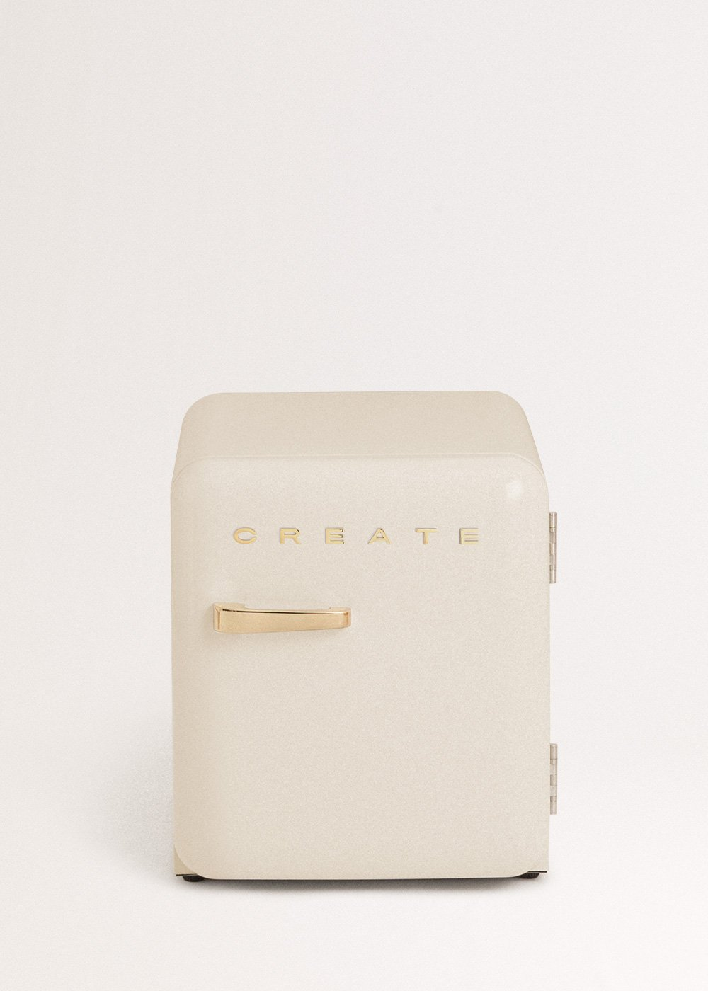 Un mini-frigorífico crema con detalles dorados y la palabra 'CREATE', sobre un fondo blanco.