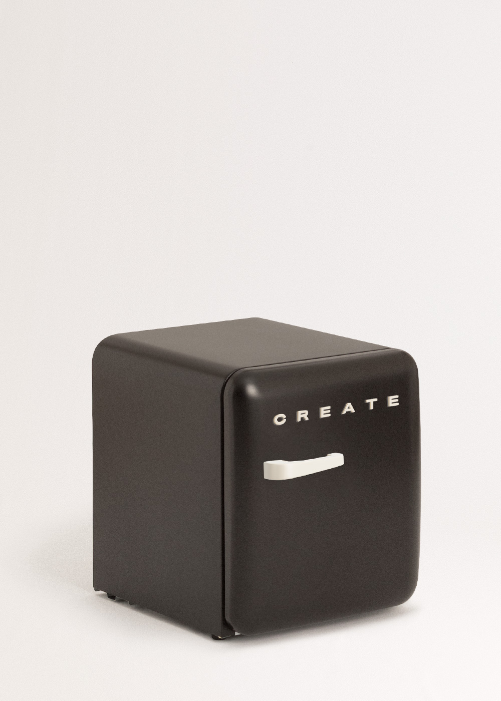 Un pequeño refrigerador negro con la palabra 'CREATE'. Tiene un asa blanca y está sobre una superficie blanca.